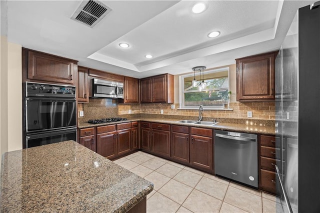 426 Devon Dr, Mandeville, LA 70448 - kitchen with black appliances, a tray ceiling, decorative backsplash, light tile patterned floors, and recessed lighting