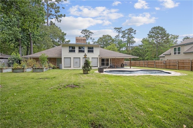 426 Devon Dr, Mandeville, LA 70448 - back of property featuring a chimney, a fenced backyard, a garden, roof with shingles, and a patio
