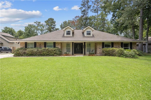 426 Devon Dr, Mandeville, LA 70448 - view of front of house with covered porch, a front lawn, brick siding, and a shingled roof