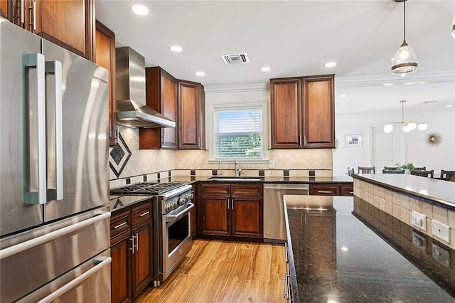 7320 General Haig St, New Orleans, LA 70124 - kitchen with appliances with stainless steel finishes, wall chimney exhaust hood, ornamental molding, pendant lighting, and tasteful backsplash