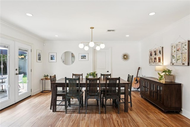 7320 General Haig St, New Orleans, LA 70124 - dining space featuring light wood finished floors, crown molding, recessed lighting, french doors, and a chandelier