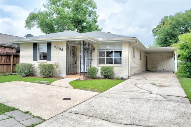 2808 Transcontinental Dr, Metairie, LA 70006 - view of front of property featuring brick siding, concrete driveway, an attached carport, and a shingled roof