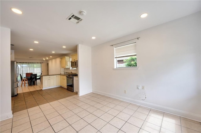 2808 Transcontinental Dr, Metairie, LA 70006 - kitchen featuring stainless steel appliances, recessed lighting, light tile patterned flooring, cream cabinetry, and a peninsula