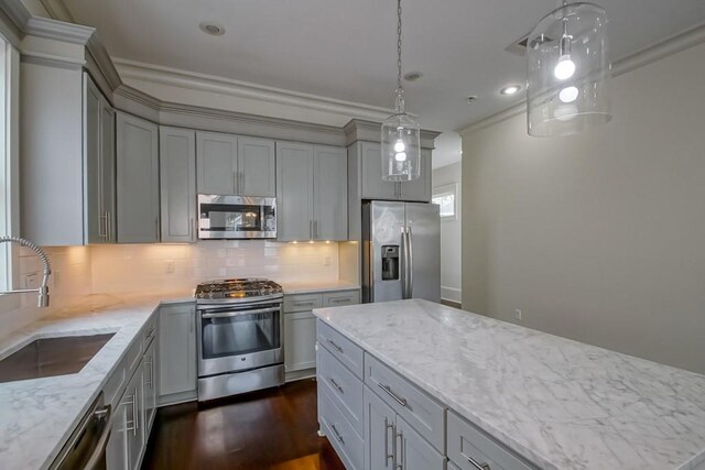 412 N Miro St, New Orleans, LA 70119 - kitchen featuring appliances with stainless steel finishes, gray cabinets, dark wood finished floors, light stone countertops, and backsplash
