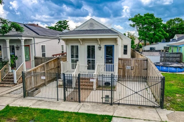 412 N Miro St, New Orleans, LA 70119 - shotgun-style home featuring a fenced front yard, a gate, and roof with shingles