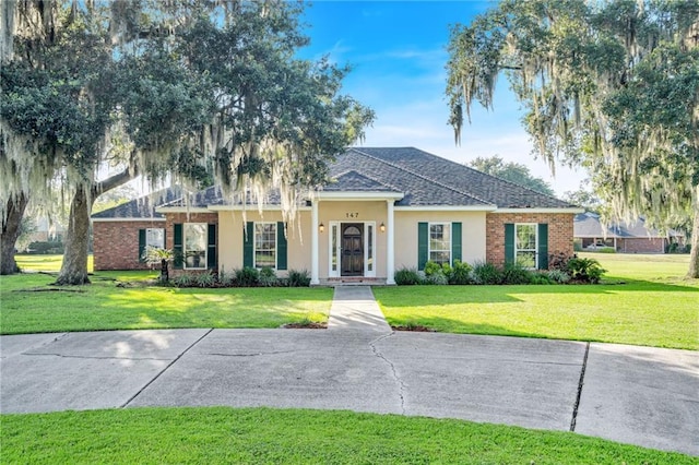 147 Jesuit Bend Dr, Belle Chasse, LA 70037 - view of front facade featuring a front lawn, stucco siding, and a shingled roof