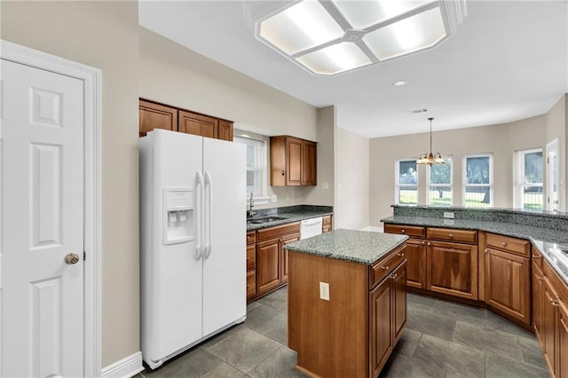 147 Jesuit Bend Dr, Belle Chasse, LA 70037 - kitchen featuring white appliances, brown cabinets, a kitchen island, a chandelier, and pendant lighting