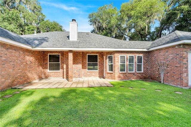 147 Jesuit Bend Dr, Belle Chasse, LA 70037 - rear view of house featuring a chimney, a yard, a patio, and brick siding