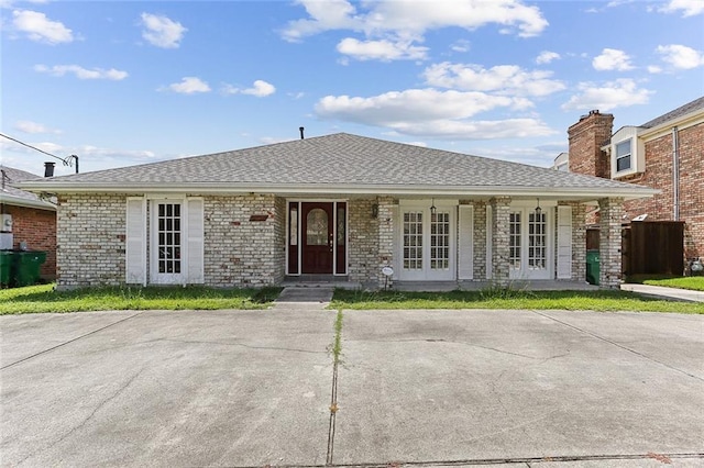 3632 N Hullen St, Metairie, LA 70002 - view of front facade featuring french doors, brick siding, a chimney, and covered porch