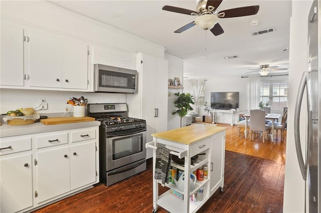 665254 General Diaz St, New Orleans, LA 70124 - kitchen with appliances with stainless steel finishes, a ceiling fan, open shelves, and dark wood-style floors