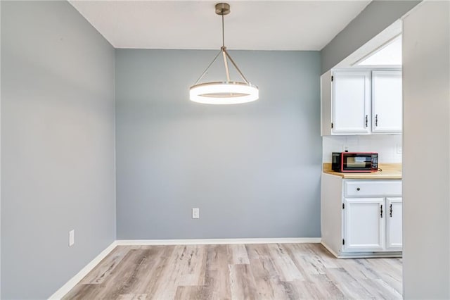 101 Wilbourn Blvd Unit 102, Lafayette, LA 70506 - unfurnished dining area with light wood-style floors and baseboards