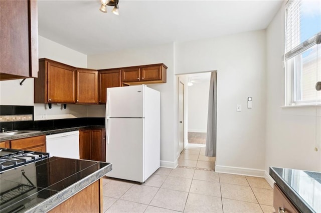 8426 Green St, New Orleans, LA 70118 - kitchen with white appliances, plenty of natural light, brown cabinetry, and light tile patterned flooring