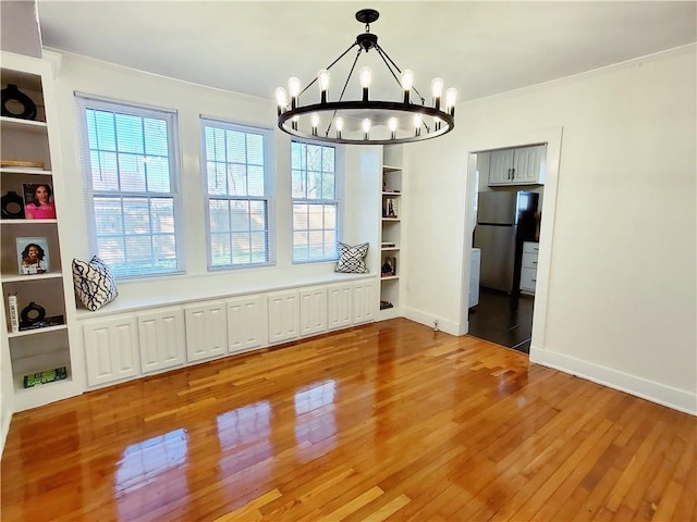 21416 N 12th St, Baton Rouge, LA 70802 - unfurnished dining area with a chandelier, crown molding, light wood finished floors, and built in features