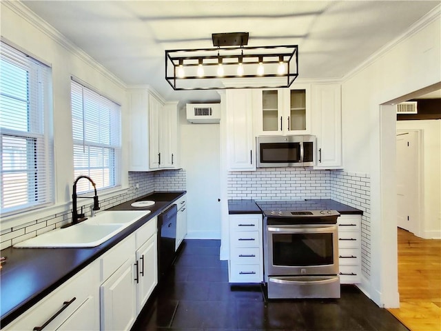21416 N 12th St, Baton Rouge, LA 70802 - kitchen with appliances with stainless steel finishes, dark countertops, white cabinets, decorative backsplash, and crown molding