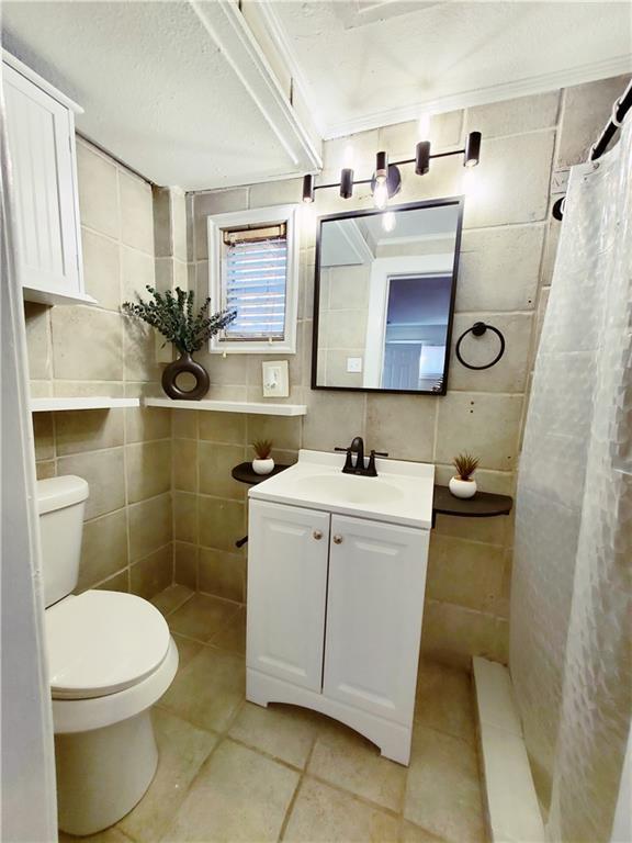 21416 N 12th St, Baton Rouge, LA 70802 - full bath with tile walls, tile patterned floors, vanity, and curtained shower
