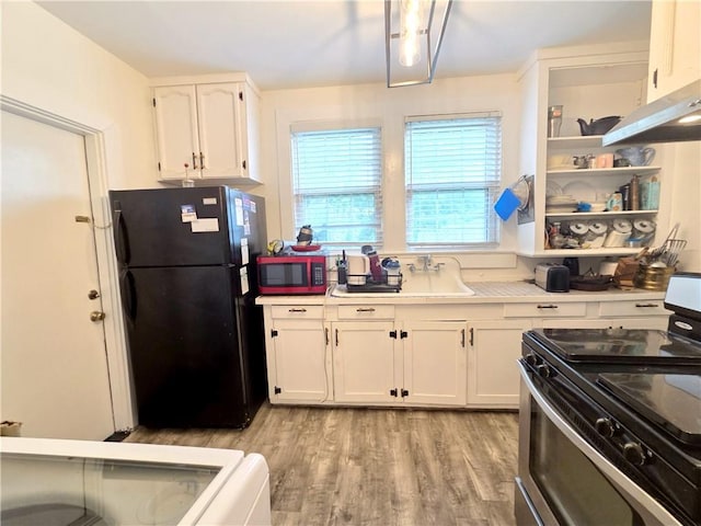 21416 N 12th St, Baton Rouge, LA 70802 - kitchen with stainless steel range with electric stovetop, freestanding refrigerator, white cabinets, light wood-style floors, and light countertops