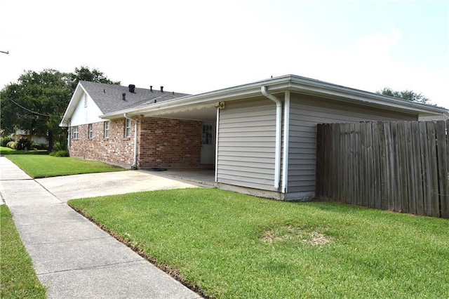 5501 Chatham Dr, New Orleans, LA 70122 - view of side of property featuring concrete driveway, a carport, brick siding, and a patio area
