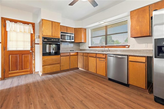 1709 Francis Ave, Metairie, LA 70003 - kitchen featuring black appliances, wood finished floors, brown cabinets, ceiling fan, and light countertops
