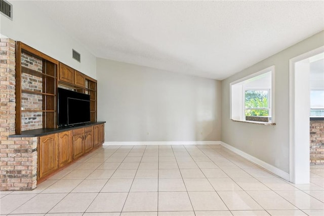4000 Kawanee Ave, Metairie, LA 70002 - unfurnished living room with a textured ceiling and light tile patterned floors