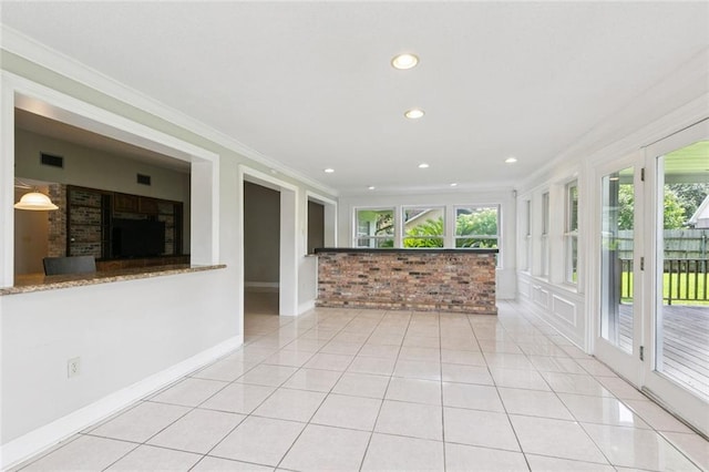 4000 Kawanee Ave, Metairie, LA 70002 - spare room with crown molding, plenty of natural light, light tile patterned floors, recessed lighting, and brick wall