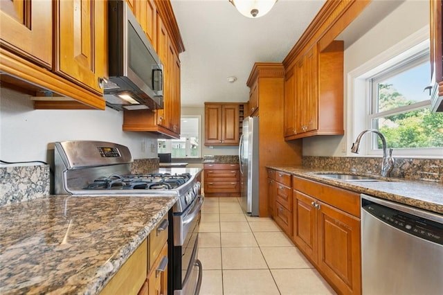 4000 Kawanee Ave, Metairie, LA 70002 - kitchen with appliances with stainless steel finishes, brown cabinetry, light tile patterned flooring, and dark stone countertops