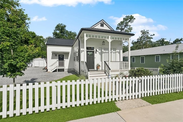702 Pine St, Madisonville, LA 70447 - view of front facade with a fenced front yard, covered porch, and a metal roof