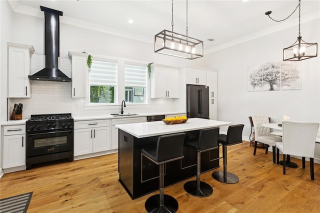702 Pine St, Madisonville, LA 70447 - kitchen featuring gas stove, fridge, wall chimney exhaust hood, light countertops, and tasteful backsplash