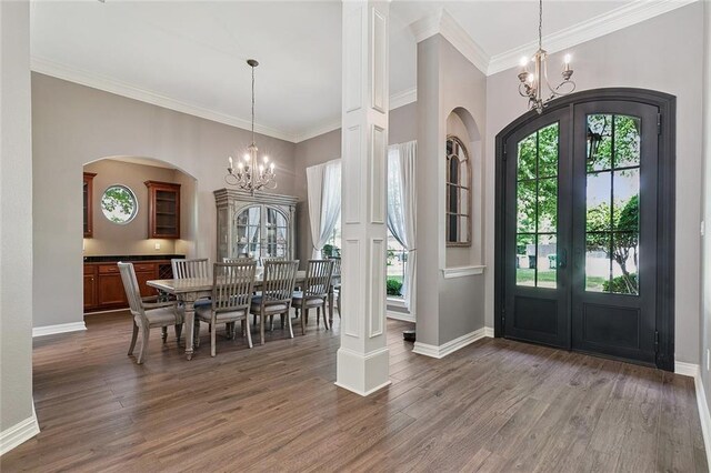 230 Delta Dr, Mandeville, LA 70448 - foyer entrance featuring a chandelier, french doors, arched walkways, wood finished floors, and crown molding