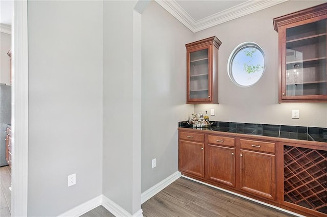 230 Delta Dr, Mandeville, LA 70448 - indoor dry bar featuring crown molding, wood finished floors, and arched walkways