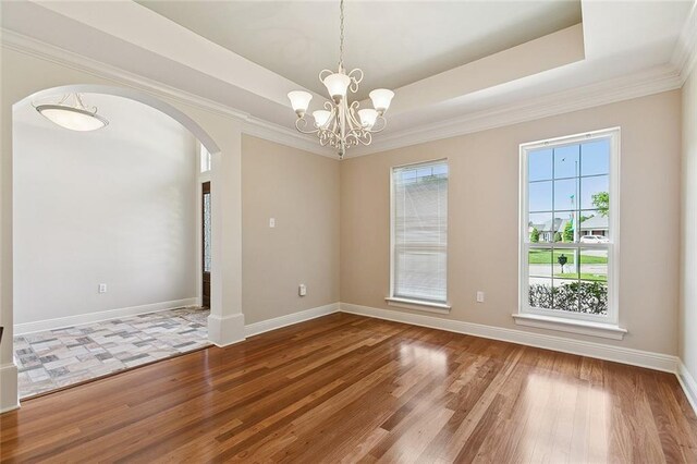 178 Colony Rd, Belle Chasse, LA 70037 - spare room featuring wood finished floors, arched walkways, a chandelier, a raised ceiling, and crown molding