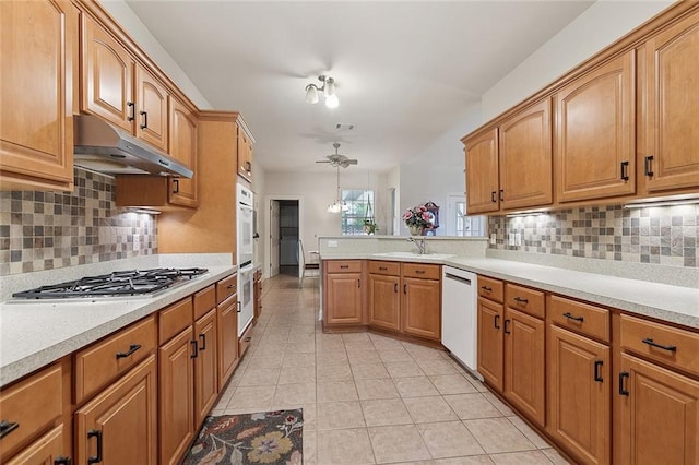 178 Colony Rd, Belle Chasse, LA 70037 - kitchen featuring under cabinet range hood, white appliances, light countertops, a peninsula, and light tile patterned flooring