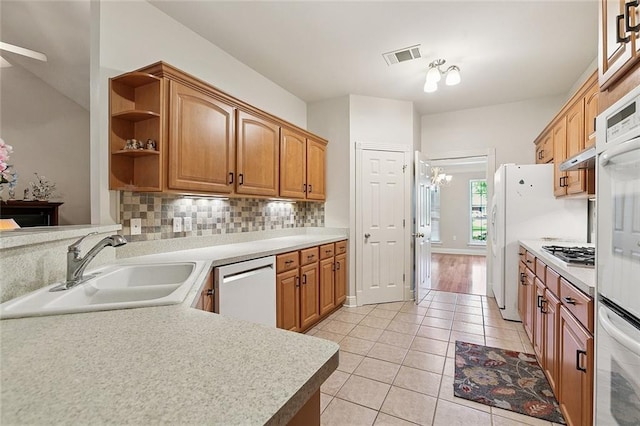 178 Colony Rd, Belle Chasse, LA 70037 - kitchen featuring appliances with stainless steel finishes, light tile patterned flooring, light countertops, open shelves, and tasteful backsplash