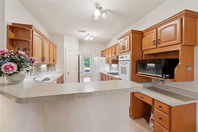 178 Colony Rd, Belle Chasse, LA 70037 - kitchen with open shelves, white appliances, under cabinet range hood, backsplash, and a peninsula