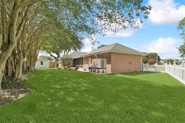 178 Colony Rd, Belle Chasse, LA 70037 - back of house with brick siding, a fenced backyard, a chimney, and a sunroom