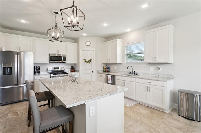 42030 Wood Ave, Ponchatoula, LA 70454 - kitchen featuring stainless steel appliances, a kitchen island, white cabinetry, a chandelier, and a breakfast bar area