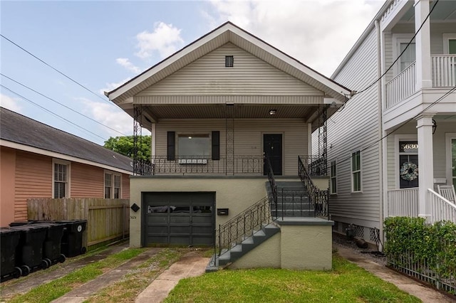 5624-5626 Annunciation St, New Orleans, LA 70115 - shotgun-style home featuring stairs, a garage, covered porch, and driveway