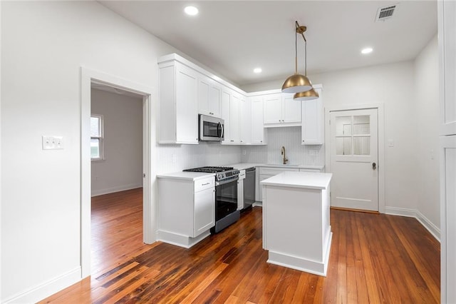 5624-5626 Annunciation St, New Orleans, LA 70115 - kitchen featuring appliances with stainless steel finishes, tasteful backsplash, dark wood-style flooring, light countertops, and recessed lighting