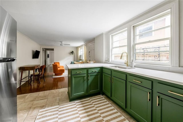 5624-5626 Annunciation St, New Orleans, LA 70115 - kitchen featuring green cabinets, freestanding refrigerator, light countertops, a ceiling fan, and a peninsula