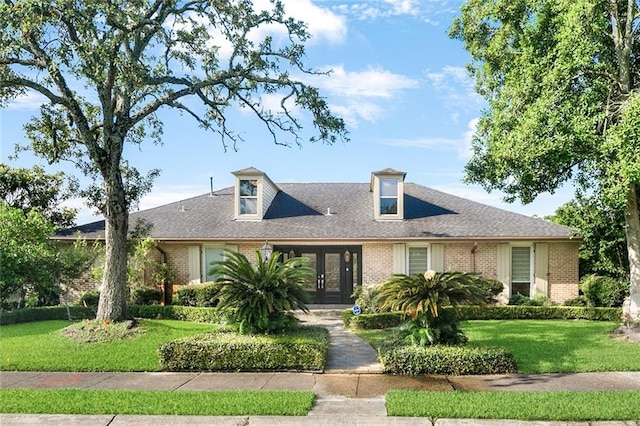 700 Crystal St, New Orleans, LA 70124 - view of front of house featuring french doors, brick siding, a front lawn, and a shingled roof