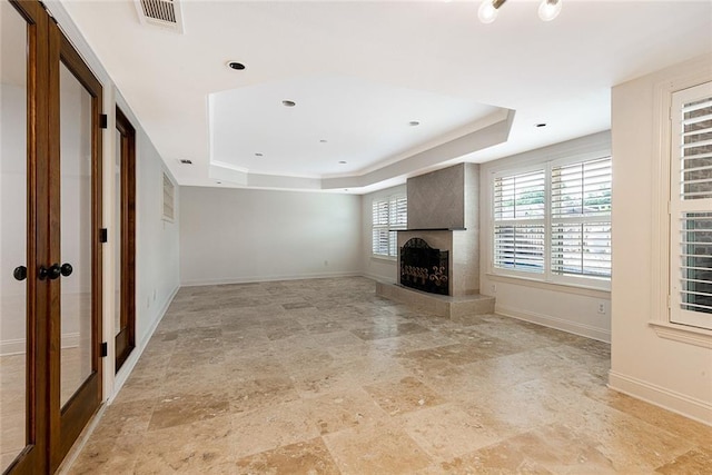 700 Crystal St, New Orleans, LA 70124 - unfurnished living room with a raised ceiling, a fireplace with raised hearth, and light stone finish flooring