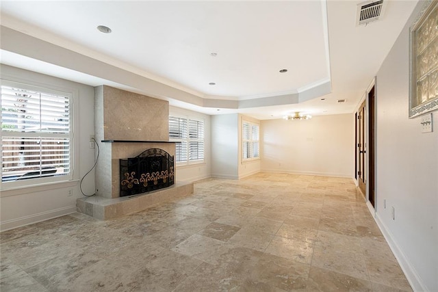 700 Crystal St, New Orleans, LA 70124 - unfurnished living room featuring a raised ceiling, crown molding, a fireplace, light stone finish flooring, and a chandelier