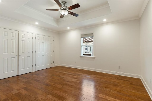 700 Crystal St, New Orleans, LA 70124 - unfurnished bedroom with a tray ceiling, multiple closets, crown molding, wood finished floors, and recessed lighting