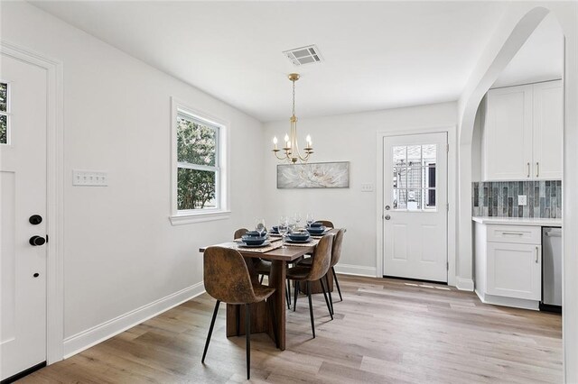 3009 Sundorn St, Jefferson, LA 70121 - dining room with light wood finished floors, a chandelier, and arched walkways