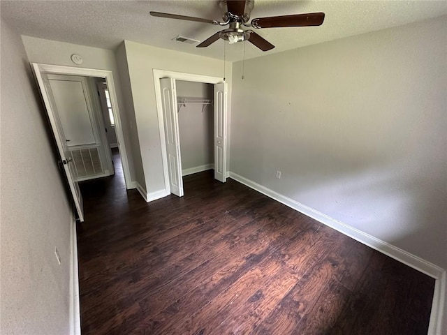1505 Saint Ann Pl, Slidell, LA 70460 - unfurnished bedroom with dark wood-style flooring, a closet, a textured ceiling, and a ceiling fan