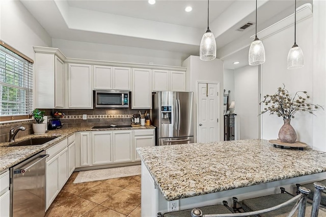 1580 Cherry Ridge Ct, Mandeville, LA 70448 - kitchen with stainless steel appliances, tasteful backsplash, a breakfast bar area, light stone countertops, and recessed lighting