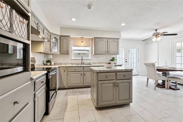 33 Rosedown Dr, Destrehan, LA 70047 - kitchen featuring gray cabinetry, stainless steel electric stove, under cabinet range hood, a kitchen island, and a textured ceiling