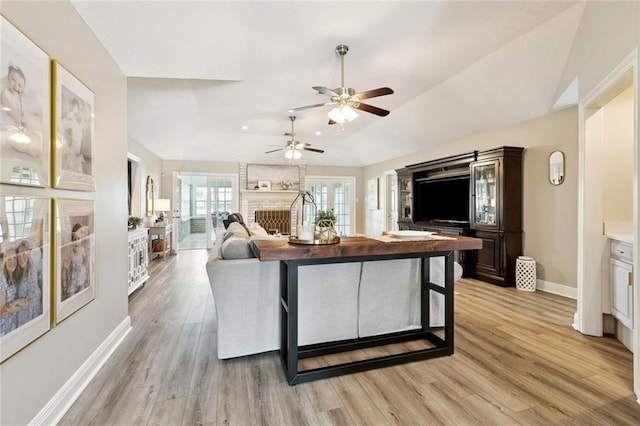 33 Rosedown Dr, Destrehan, LA 70047 - living area featuring light wood-style flooring, a fireplace, vaulted ceiling, and a ceiling fan