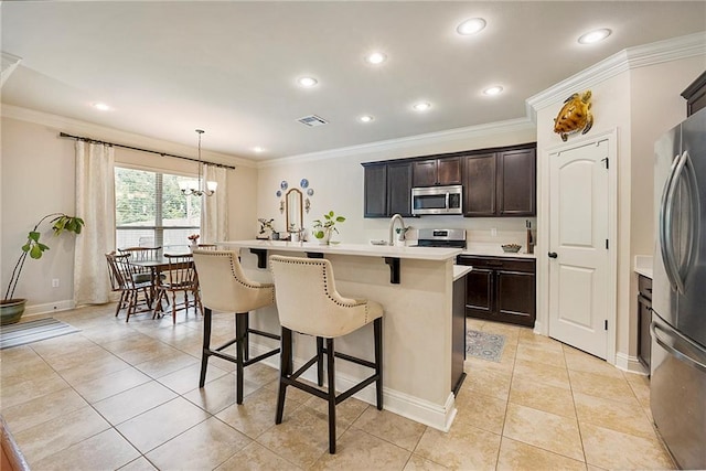 17509 Waterloo Dr, Baton Rouge, LA 70817 - kitchen with appliances with stainless steel finishes, a kitchen bar, a chandelier, an island with sink, and crown molding