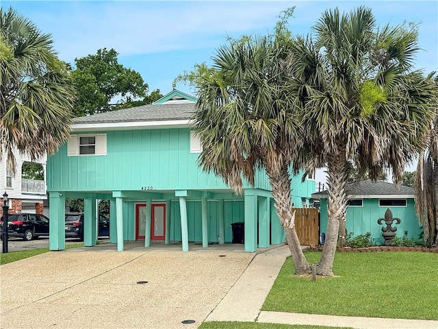 4230 Murano Rd, New Orleans, LA 70129 - view of front of home with a carport, driveway, and a shingled roof