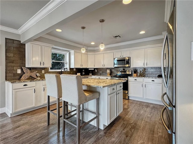 4230 Murano Rd, New Orleans, LA 70129 - kitchen with appliances with stainless steel finishes, a center island, white cabinetry, light stone counters, and dark wood-type flooring